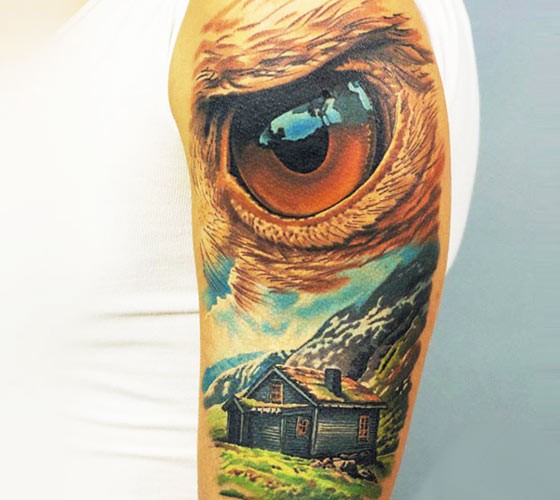 Illustrative style colored shoulder tattoo of mountain house with eagle eye