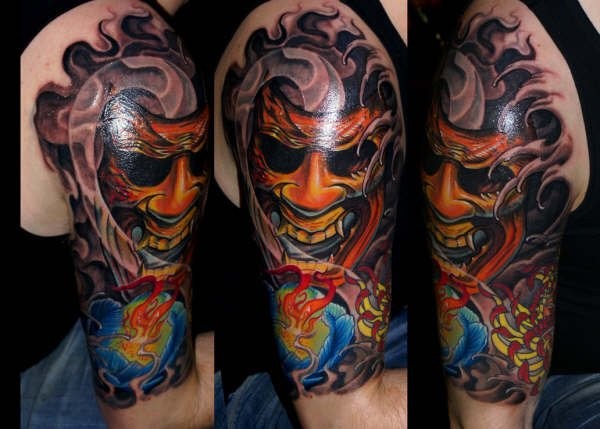 Illustrative style colored shoulder tattoo of demonic mask with fog
