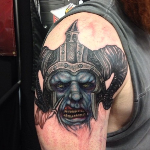 Illustrative style colored shoulder tattoo of demonic warrior head