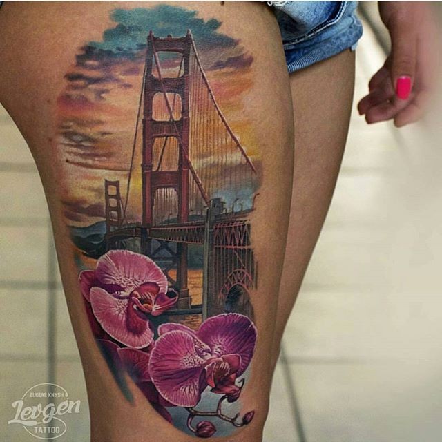 Illustrative style colored thigh tattoo of Golden Gate bridge and flowers