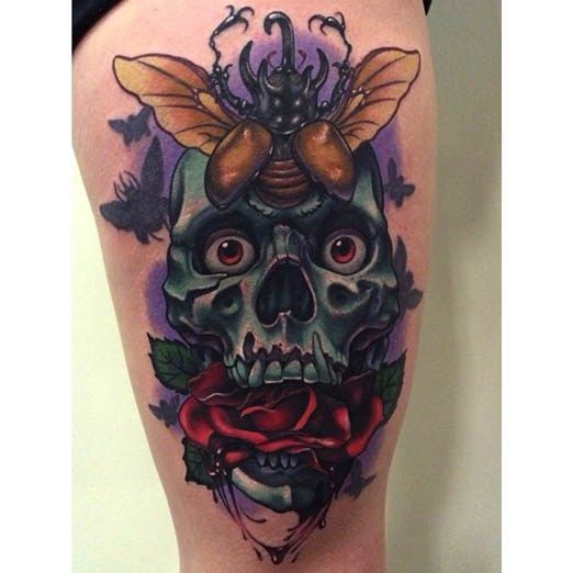 Illustrative style colored thigh tattoo of creepy skull with rose and bug