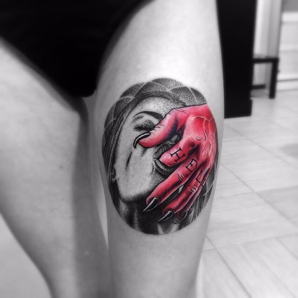 Illustrative style colored thigh tattoo of woman face with demons hand