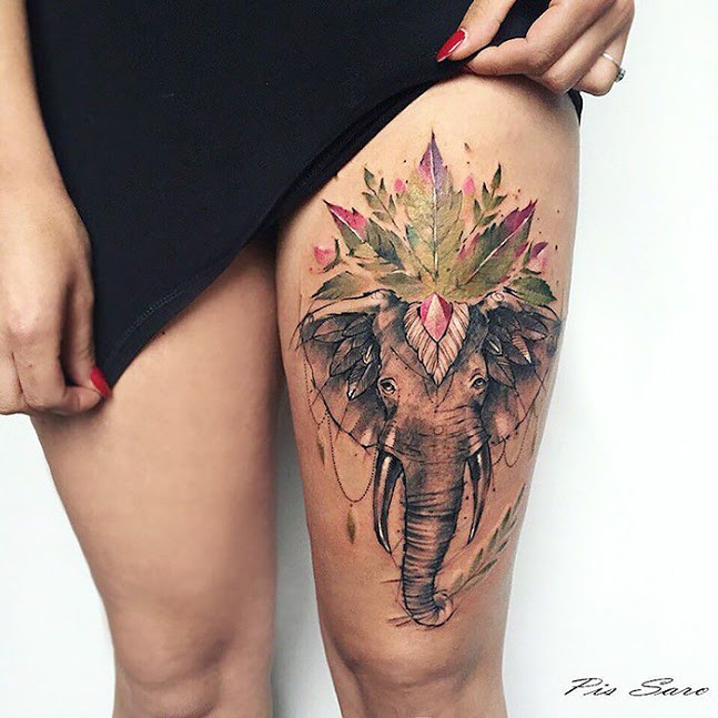 Illustrative style colored thigh tattoo of elephant with clover leaf