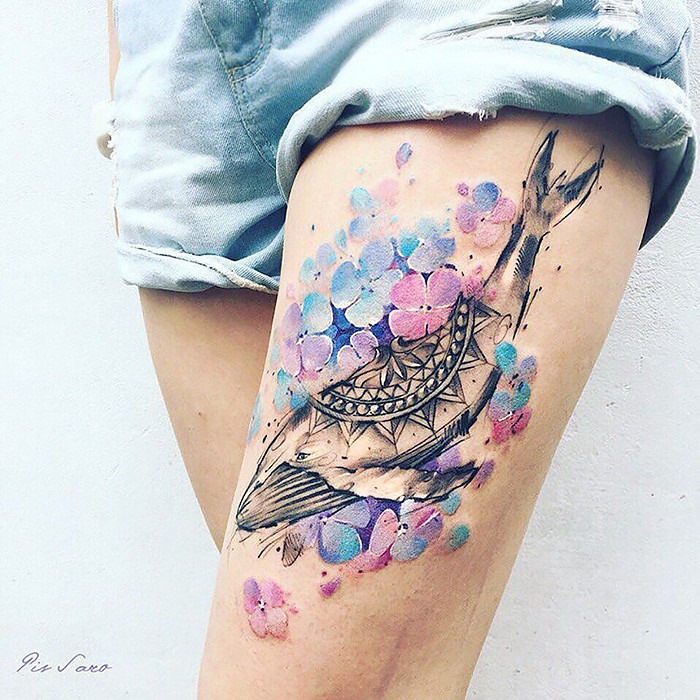 Illustrative style colored thigh tattoo of whale with flowers