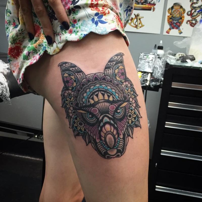Illustrative style colored thigh tattoo of fantasy wolf with ornaments