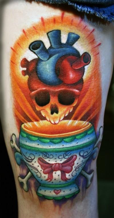 Illustrative style colored thigh tattoo of interesting looking cup with skull and heart