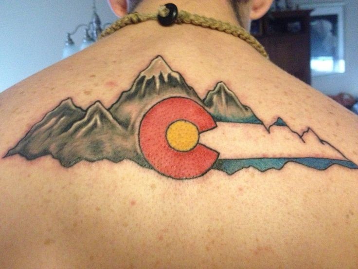 Illustrative style colored upper back tattoo of mountains and national flag
