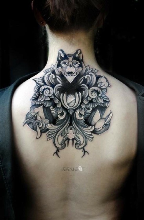Illustrative style upper back tattoo of wolf with flowers