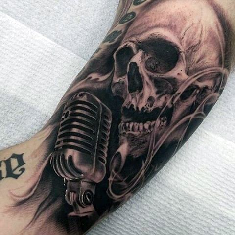 Tatuaje en el brazo, cráneo humano con micrófono retro