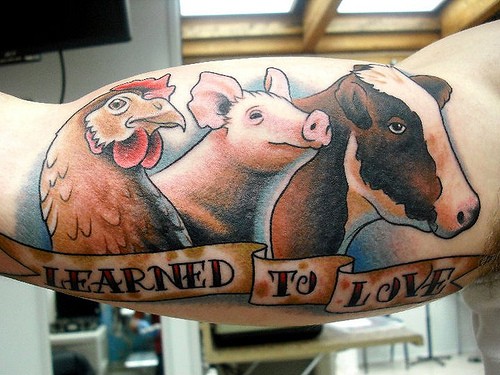 Beeindruckende cartoonische farbige Tiere mit Schriftzug Tattoo am Arm