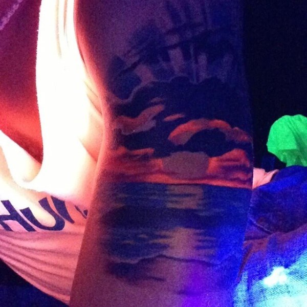Tatuaje en el brazo,  mar a puesta de sol, diseño pintoresco