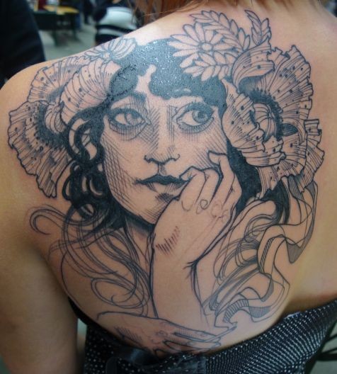 Impressive gorgeous looking black ink scapular tattoo of woman with flowers