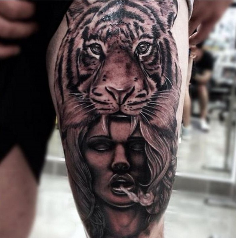 Beeindruckend aussehendes schwarzes und weißes Oberschenkel Tattoo mit Tribal Frau in der Tigers Haut