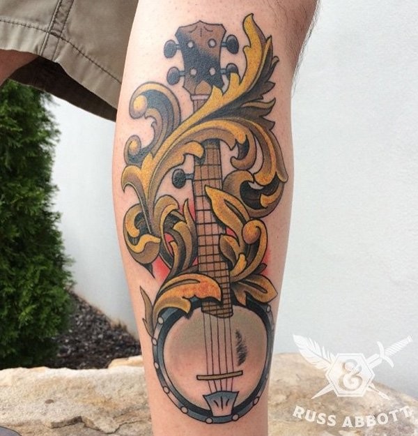 Impressive old school painted colored music instrument tattoo on leg