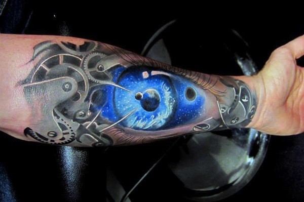 Tatuaje en el antebrazo, ojo azul estupendo entre mecanismos