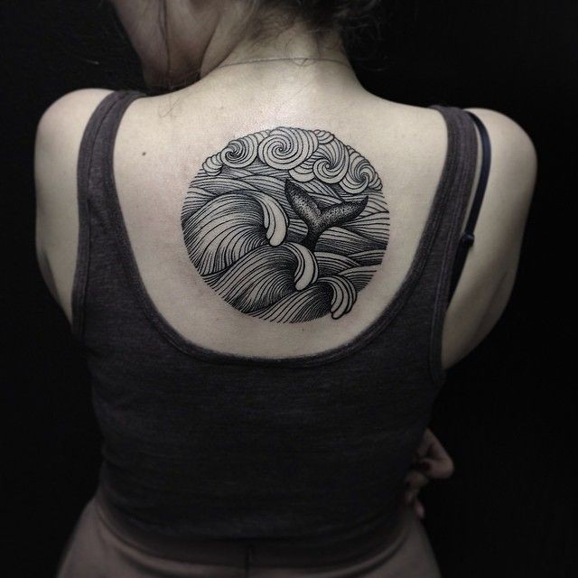 Tatuaje en la espalda, cola de ballena en ondas de mar, colores negro y blanco