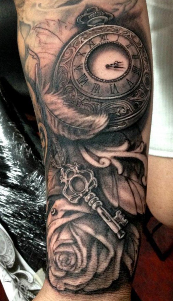 Tatuaje en el antebrazo,
reloj antiguo combinado con pluma, llave y rosa