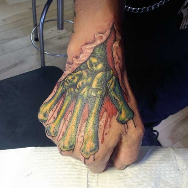 Impressive zombie like colored skeleton hand tattoo on fist