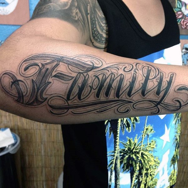 Tatuaje en el antebrazo, palabra familia, tinta negra