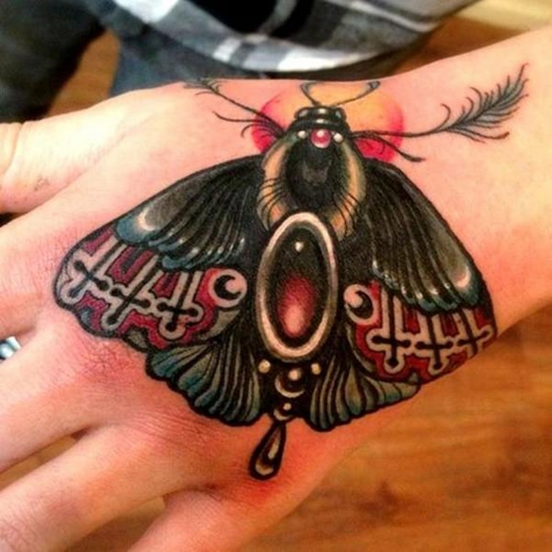 Incredible jewelry like colored butterfly tattoo on hand stylized with various ornaments