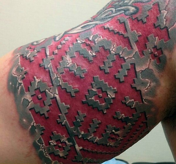 Incredible looking colored ornamental style tattoo on biceps