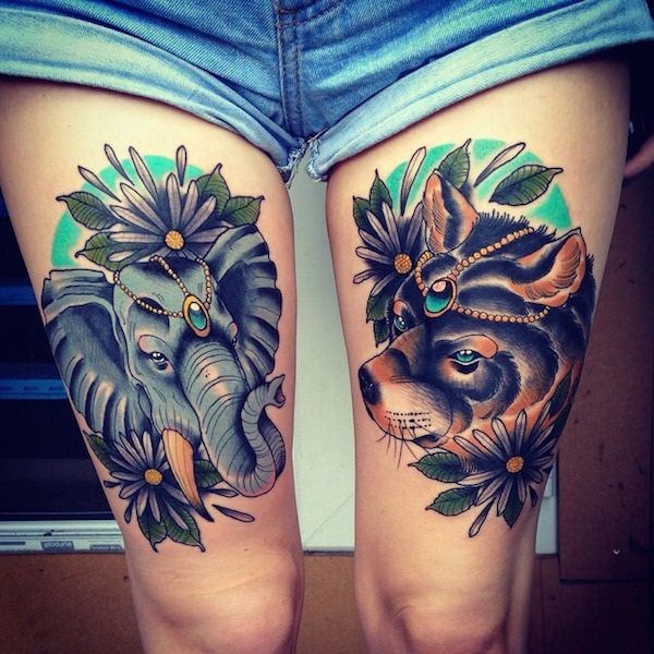Tatuaje colorido en los muslos, 
elefante con lobo decorados con flores y joyas