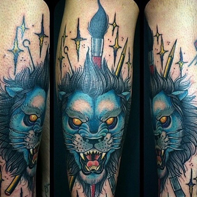 Tatuaje en el brazo,
león azul furioso con pincel y estrellas
