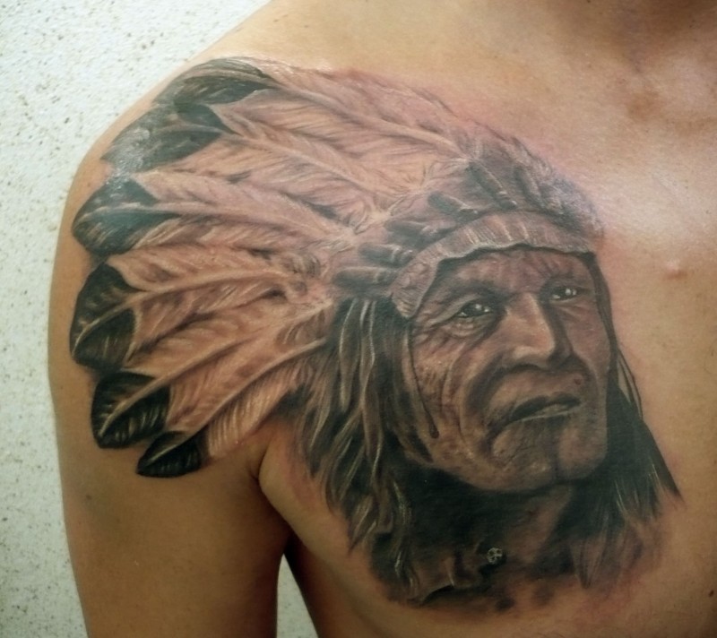 Indian with feathers on his head shoulder and chest tattoo