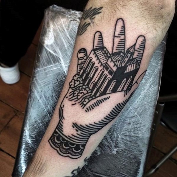 Industrial style black ink old castle in hand tattoo on arm