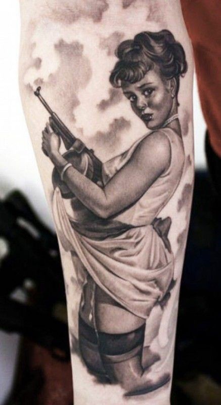 Tatuaje en el antebrazo, chica en rodillas con pistola