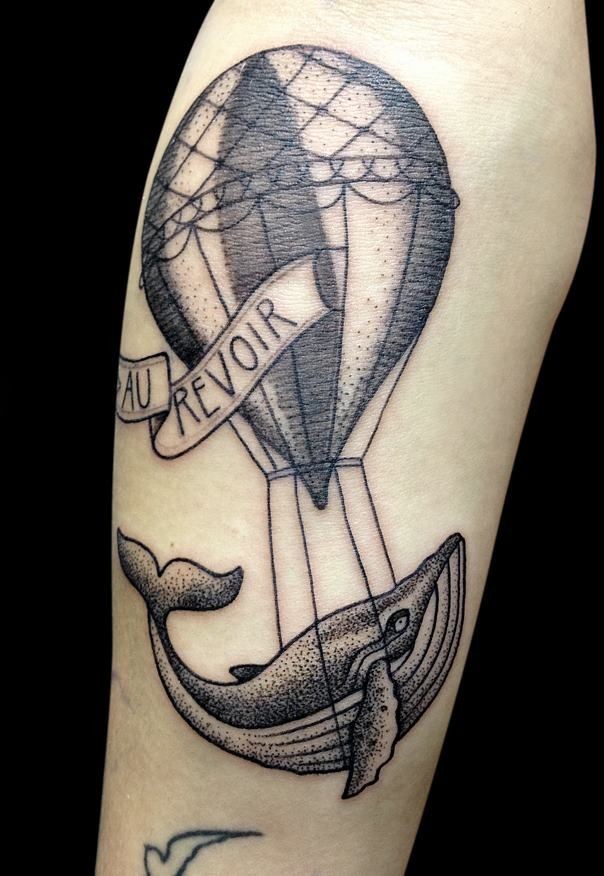 Interesting black ink balloon with whale tattoo on forearm stylized with lettering