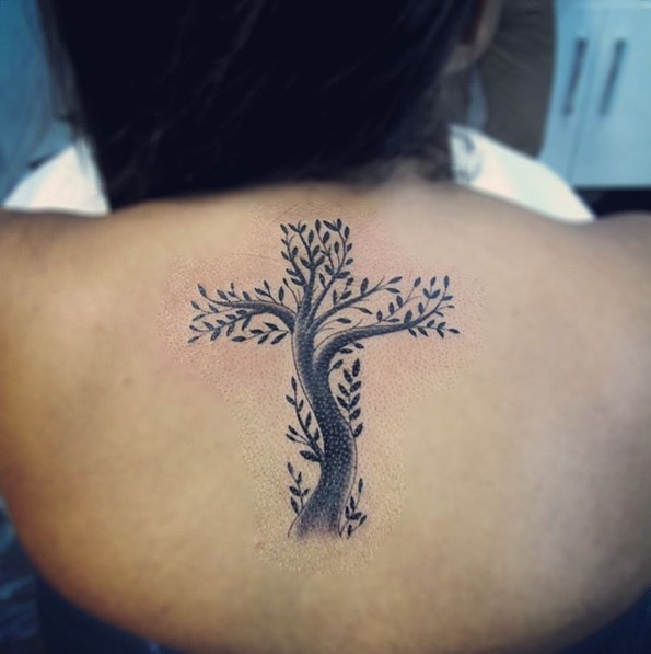 Tatuaje en la espalda, árbol con hojas formadas una cruz, color negro