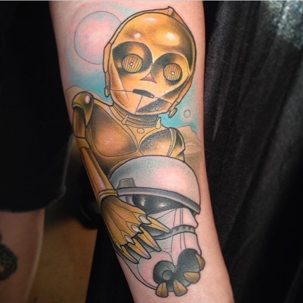 Interesting cartoon like colored C3PO droid with storm troopers helmet tattoo on forearm