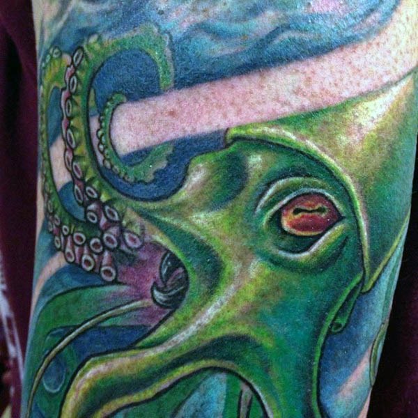 Interesting colored big detailed squid tattoo on arm
