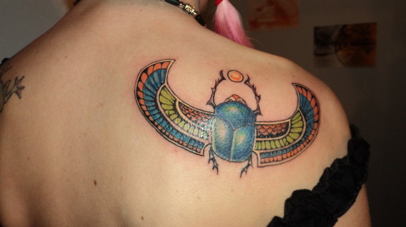 Interessant gestalteter und farbiger Käfer mit Vogelflügel Tattoo am Rücken