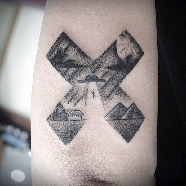Tatuaje en el brazo, cruz estilizado con nave extraterrestre