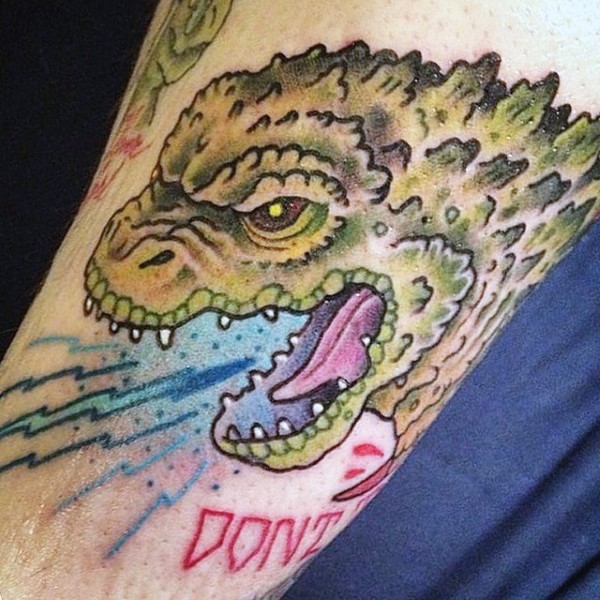 Interesting designed cartoon colored Godzilla tattoo on arm