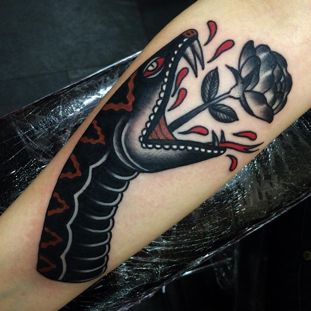Interesting looking colored arm tattoo of big snake with rose