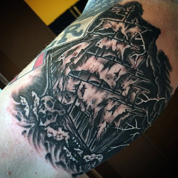 Tatuaje en el brazo, barco pirata con velas gastadas