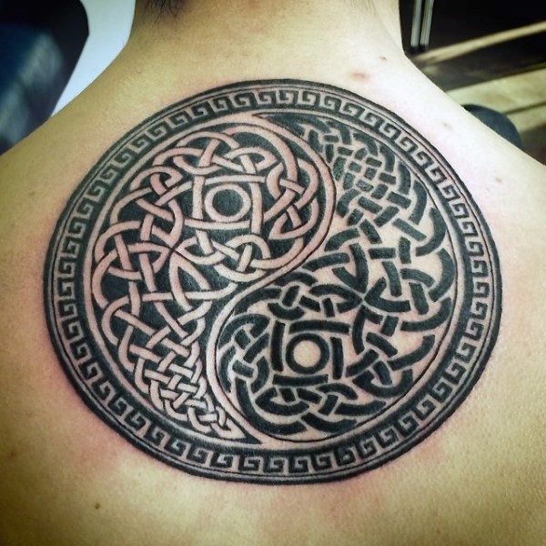 Interesting Yin Yang symbol shaped upper Celtic style upper back tattoo