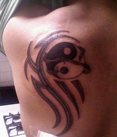 Tatuaje en el hombro, yin yang con adornos tribales