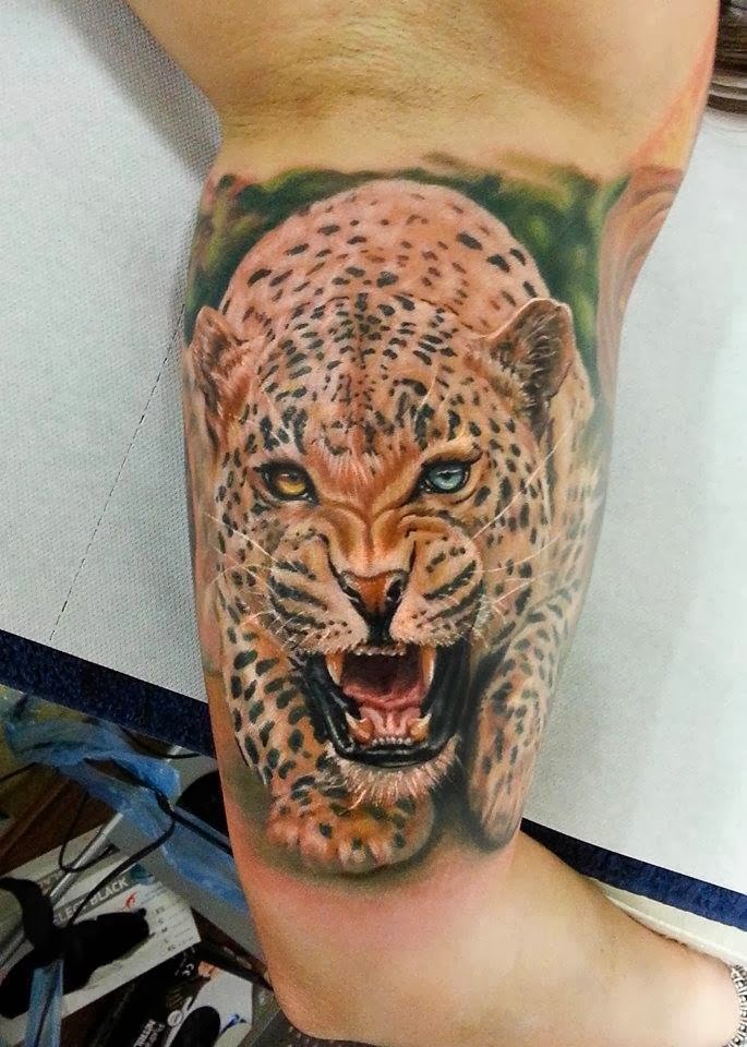 Tatuaje en el brazo,
jaguar con ojos de colores diferentes que caza