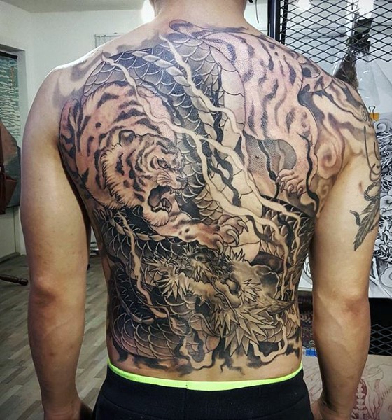 japanese traditional black ink whole back tattoo of tiger with dragon