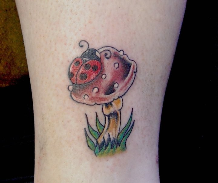 Ladybug on a mushroom tattoo on leg