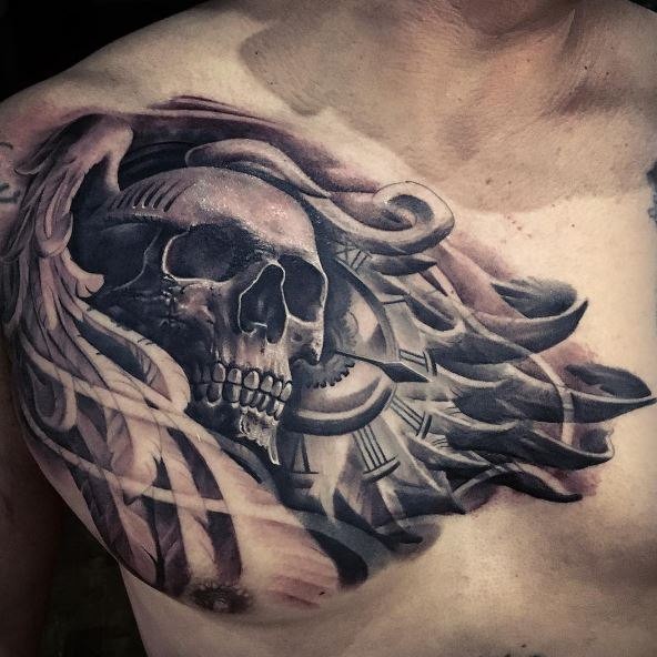 Large 3D style detailed chest tattoo of human skull with clock and wings