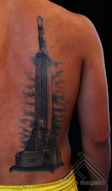 Large amazing looking back tattoo of enormous stone statue
