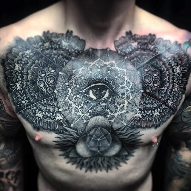 Large beautiful looking chest tattoo of various ornamental flowers with eye