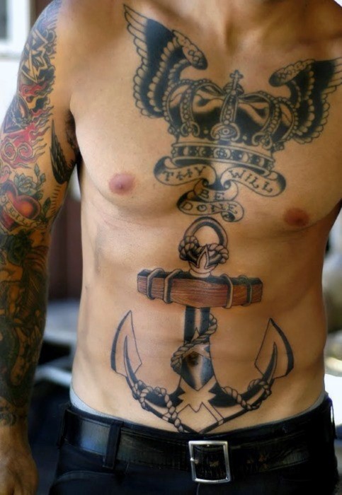 Large black ink chest and belly tattoo of king crown with wings, lettering and big anchor
