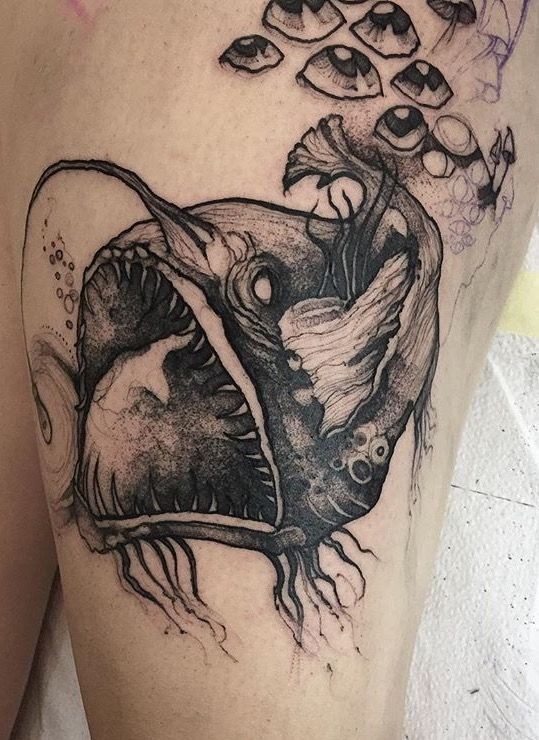 Large black ink painted by Joanna Swirska thigh tattoo of demonic fish