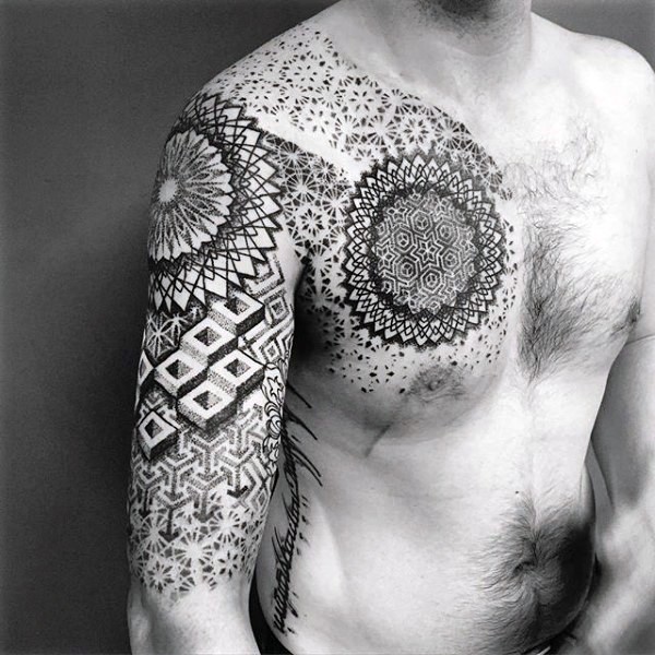 Large black ink shoulder and chest tattoo of ornamental flowers and geometrical figures